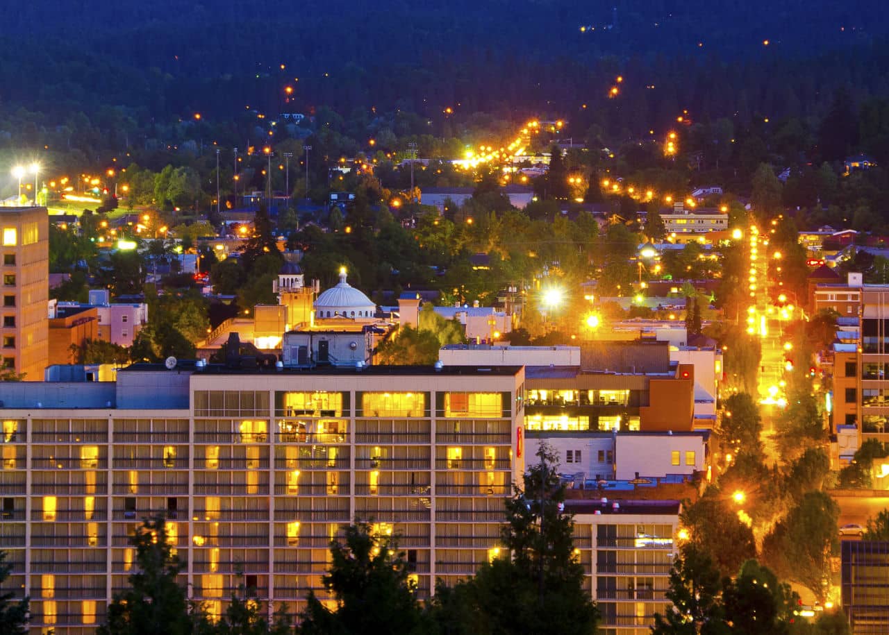 Golden lights illumniate the skyline of a summer evening in Eugene, Oregon as viewed from the top of Skinners Butte.