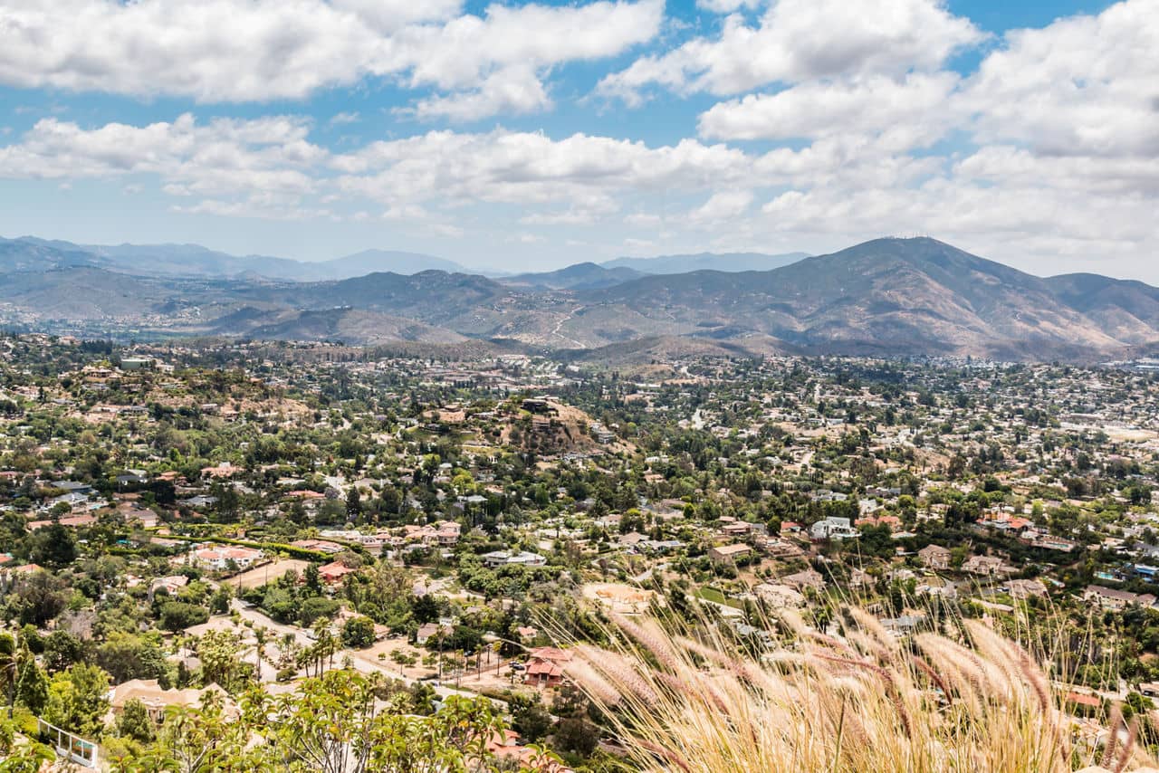 Aerial view of La Mesa, California showcasing treelined streets and mountain ranges in background.