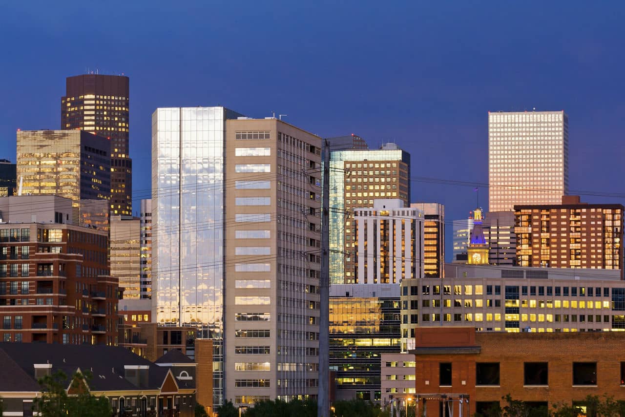 Denver skyline at dusk with colorful sunset reflection in the windows