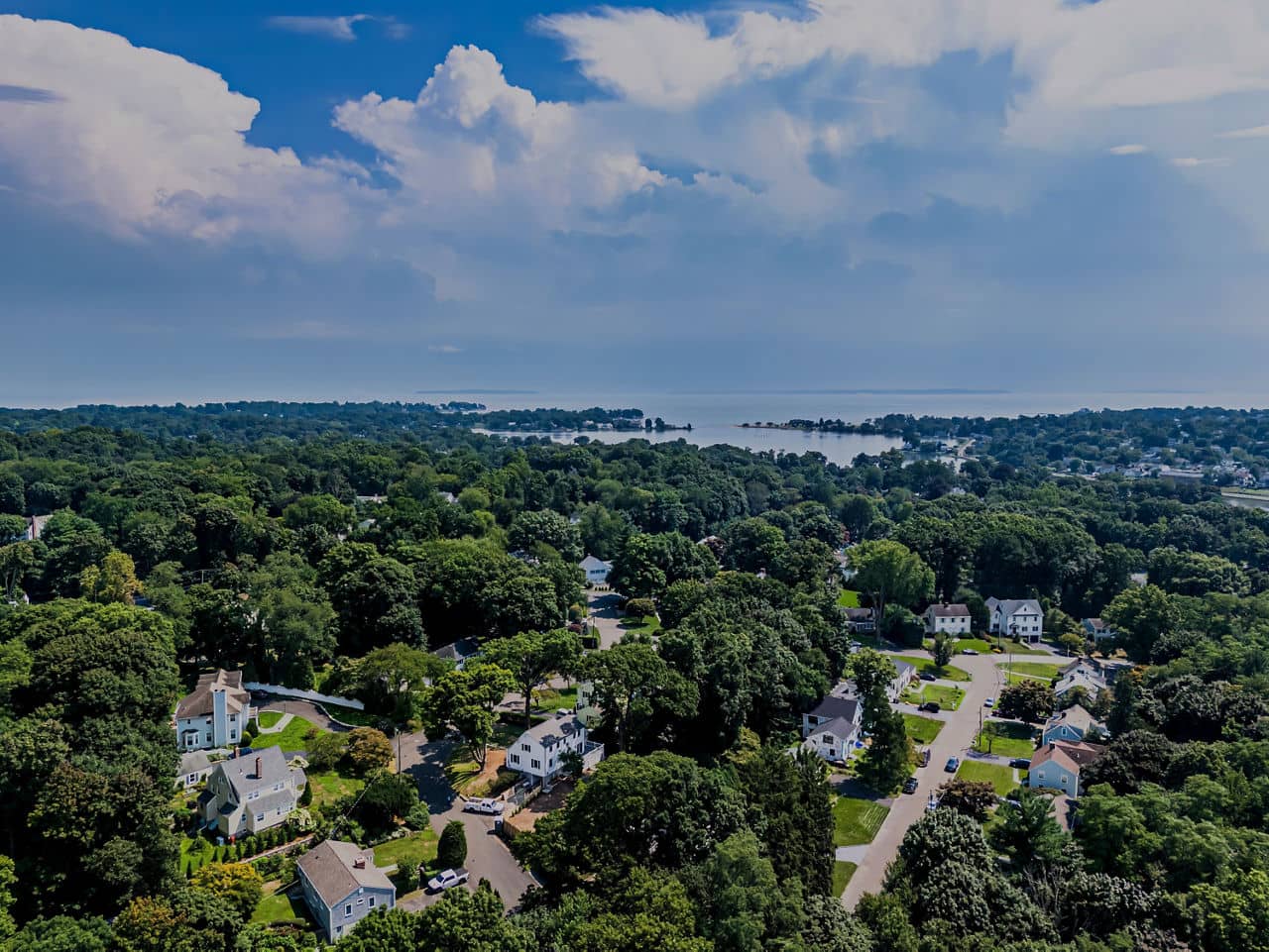 A high angle, aerial view over a residential neighborhood of Darien, Connecticut on a sunny day.