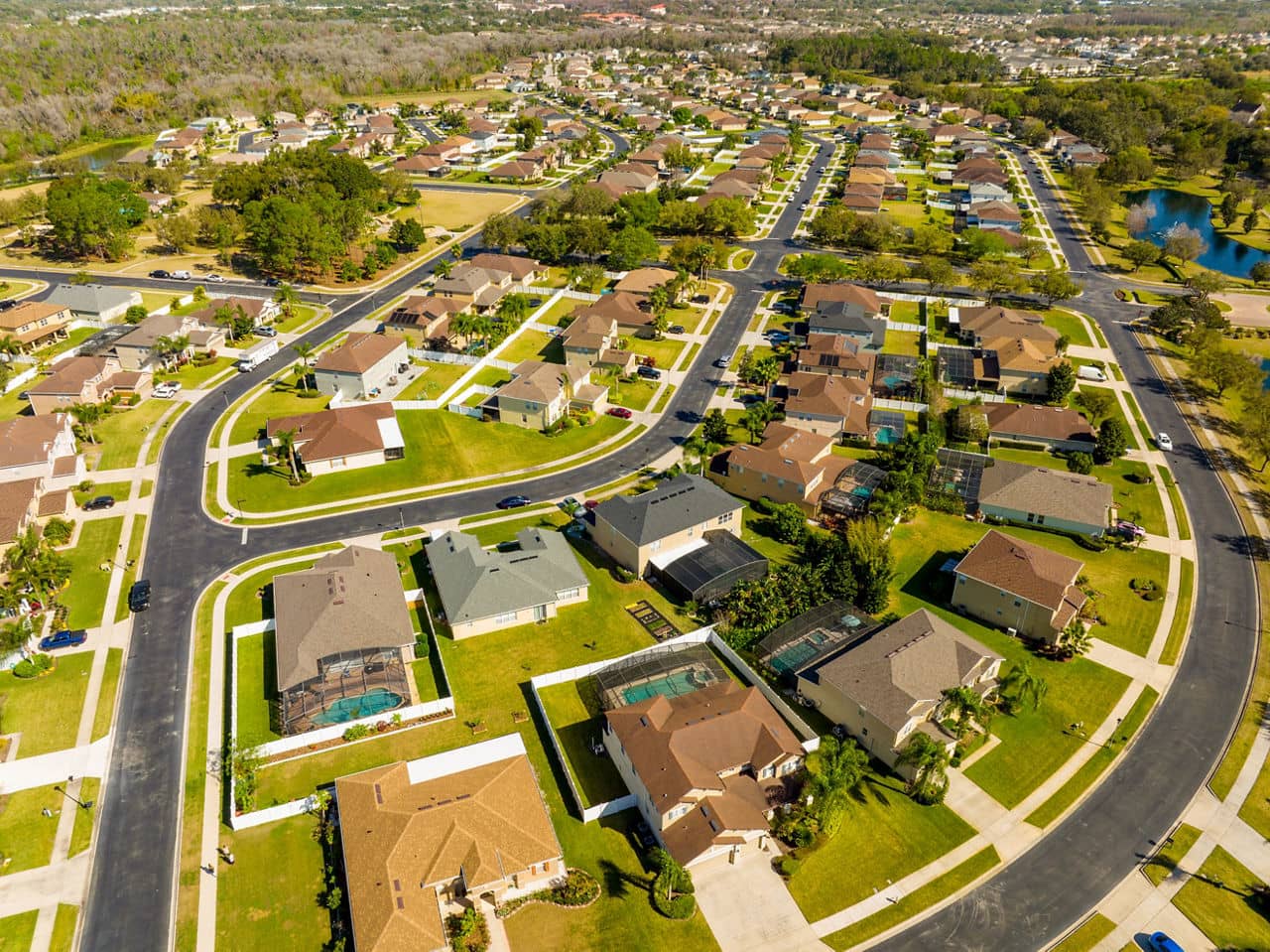  Aerial view of Horizon West, Florida, showing curved suburban streets lined with houses, many with pools and green lawns.