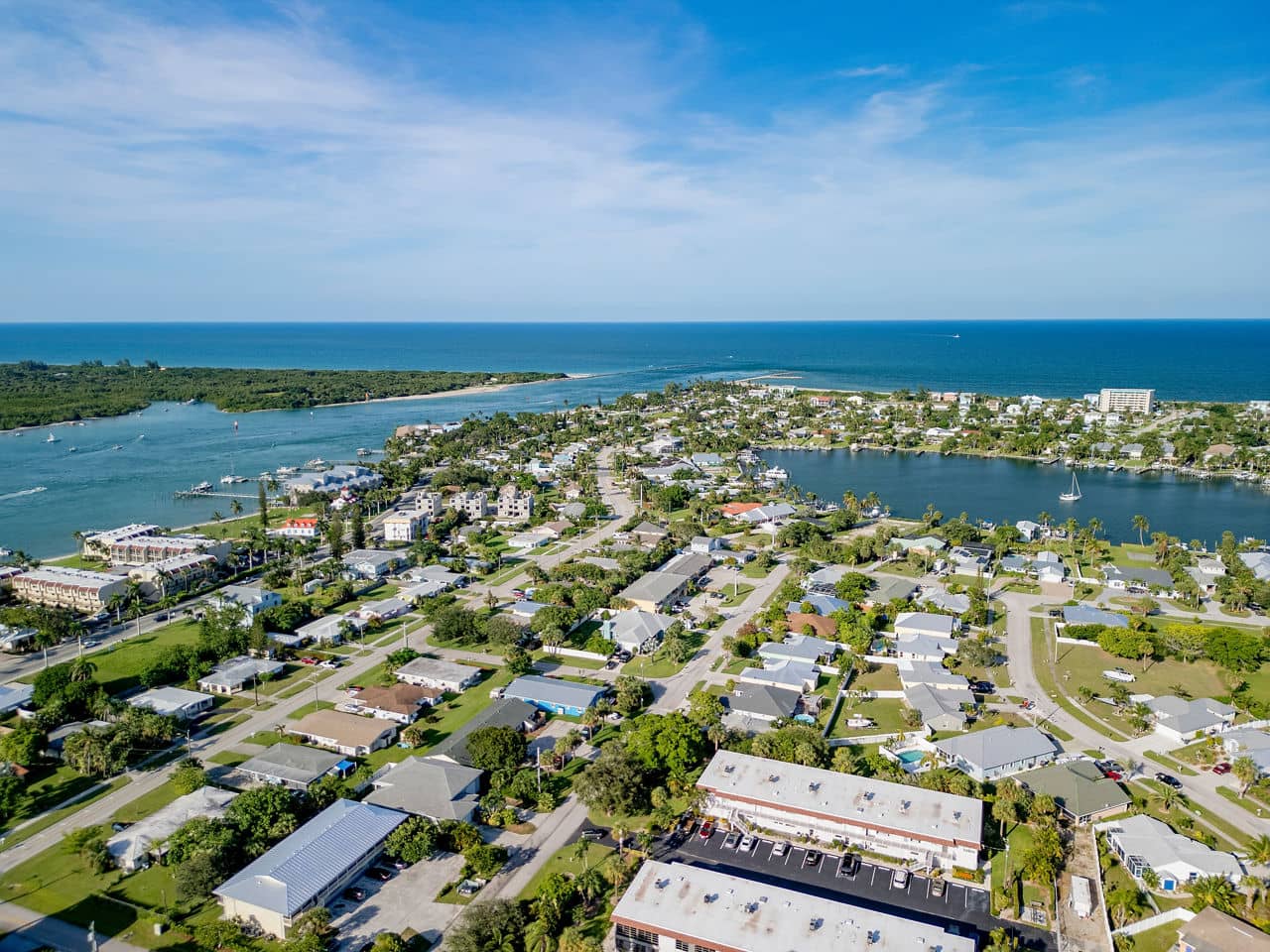 Aerial view of Port St. Lucie, Florida, showing residential neighborhoods between waterways, with the Atlantic Ocean in the background.