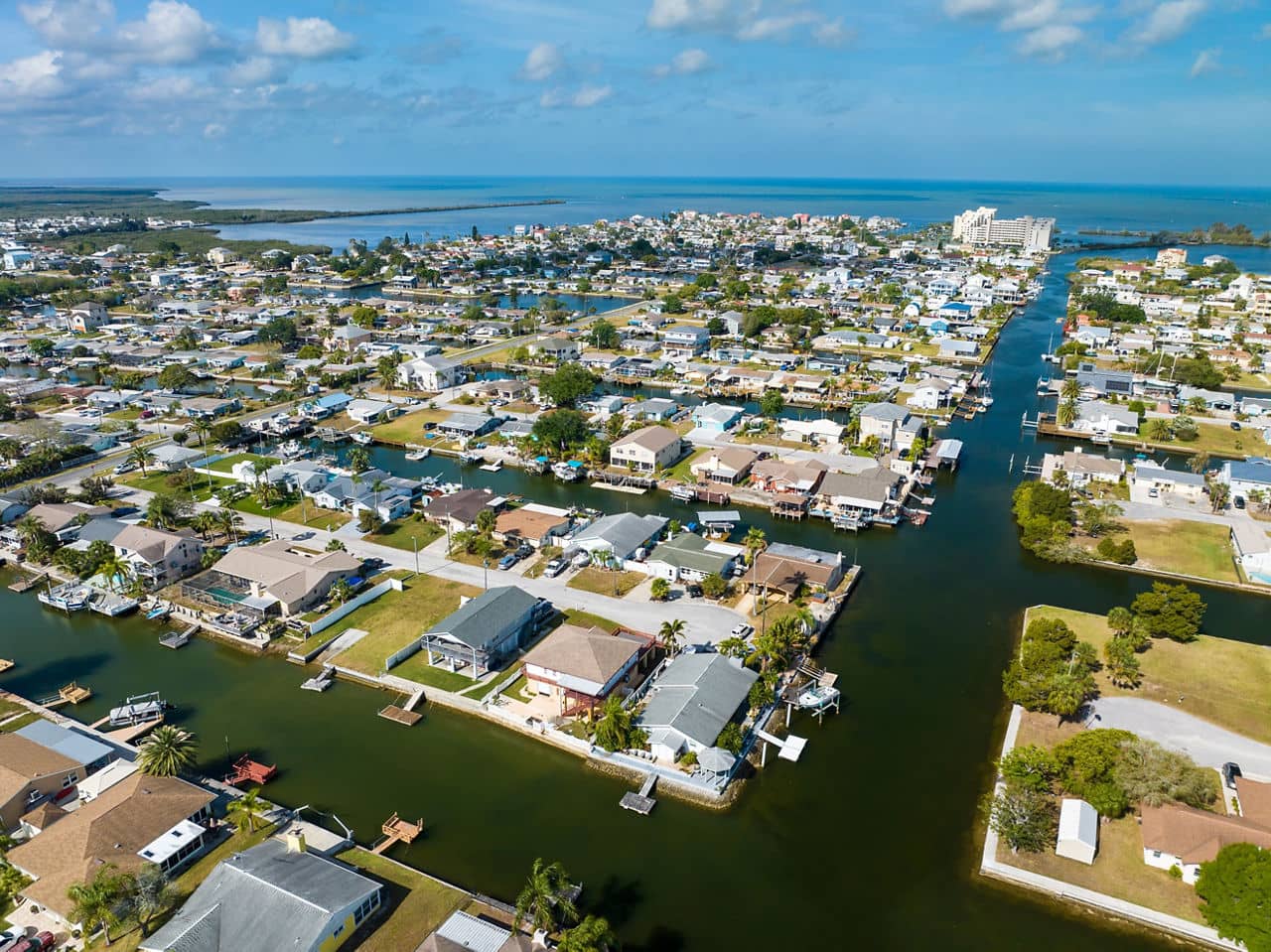 Aerial view of Pasco County, Florida, showing waterfront homes with boat docks along canals, leading to the Gulf of Mexico.