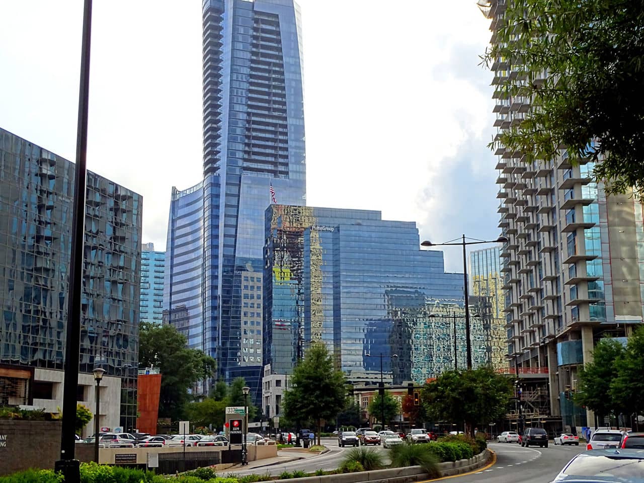Modern glass skyscrapers and high-rise buildings in Sandy Springs/Roswell/North Fulton Area, GA with street traffic below.