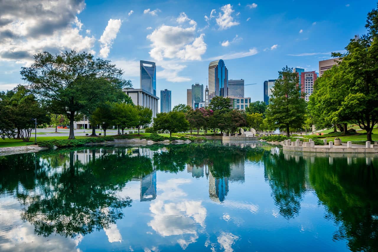 Uptown Charlotte, North Carolina skyline with skyscrapers reflecting in Marshall Park lake.