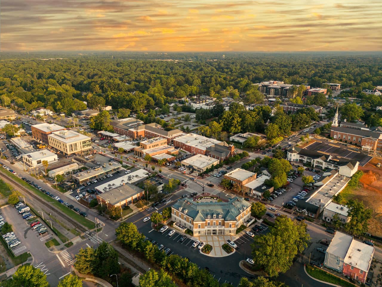 Aerial view of the thriving Downtown Cary Park with a skywalk and water fountain, located in Cary, North Carolina.