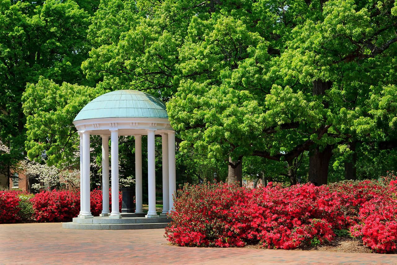 The Old Well, a UNC Chapel Hill landmark, is framed by vibrant pink azaleas in the springtime, Chapel Hill, North Carolina.