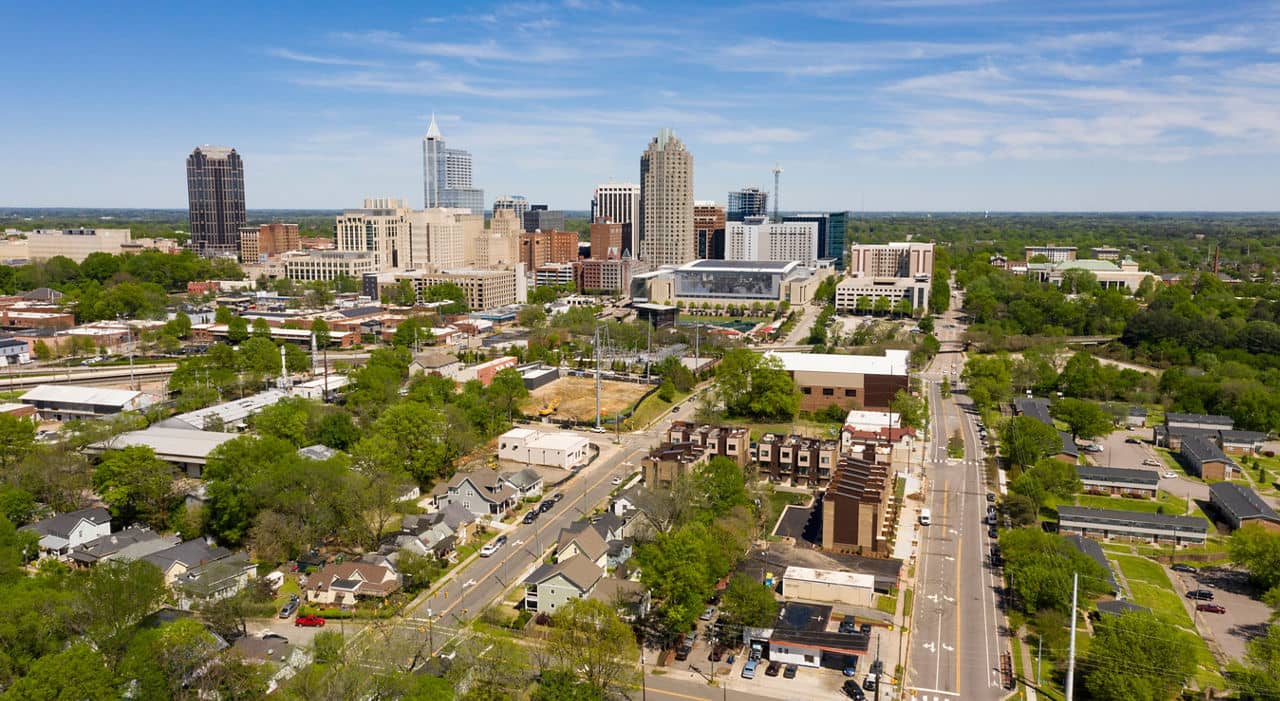 Aerial view of the urban downtown Raleigh, North Carolina, metro area skyline at sunrise, showing the city's unique charm.