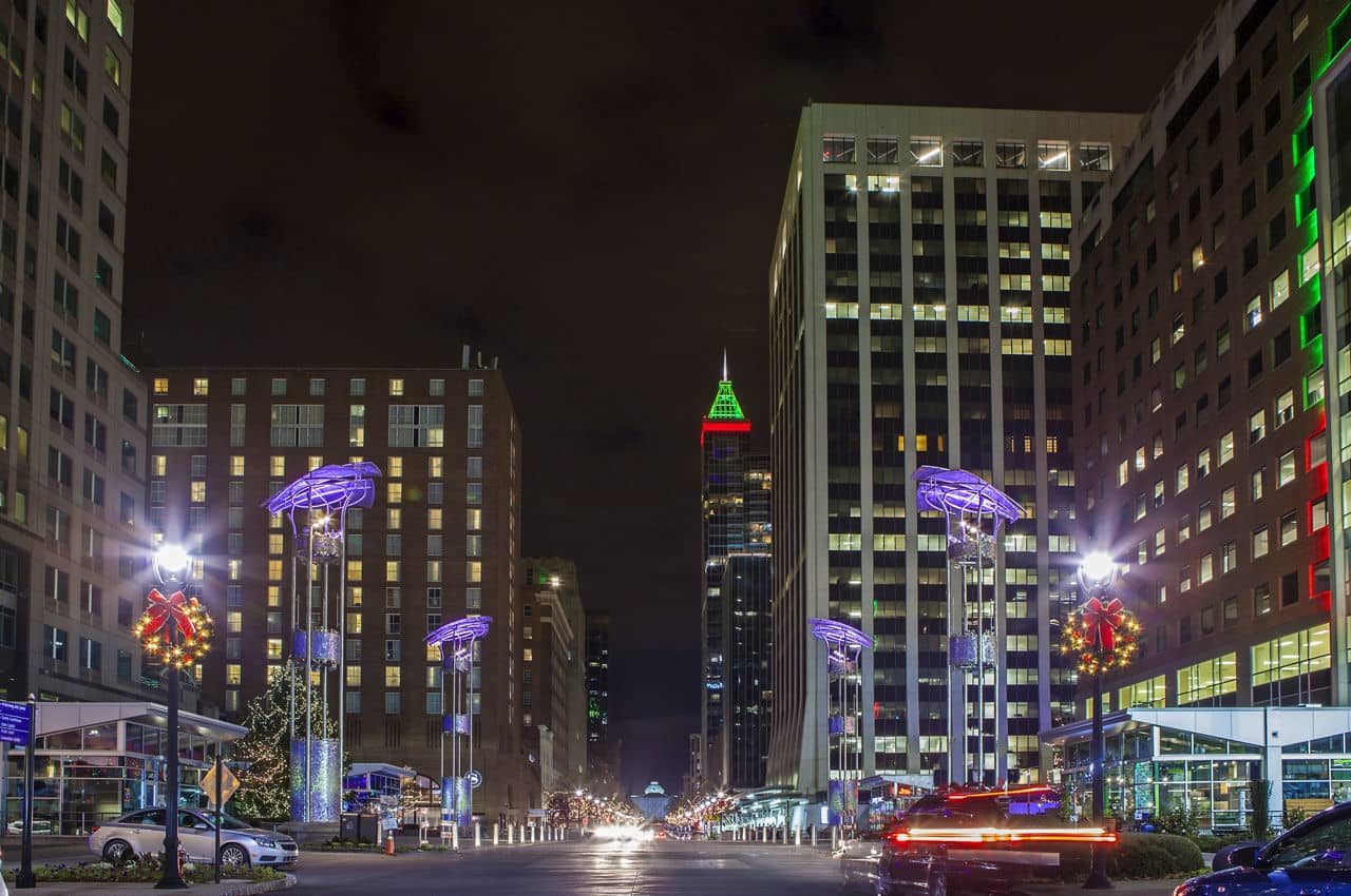Night view of modern city from street level, no recognizable people in shot.