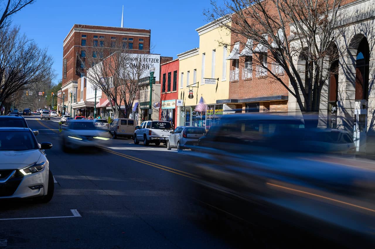 A downward view of Union Street in downtown with motion blur cars driving down the main street in Concord, NC.