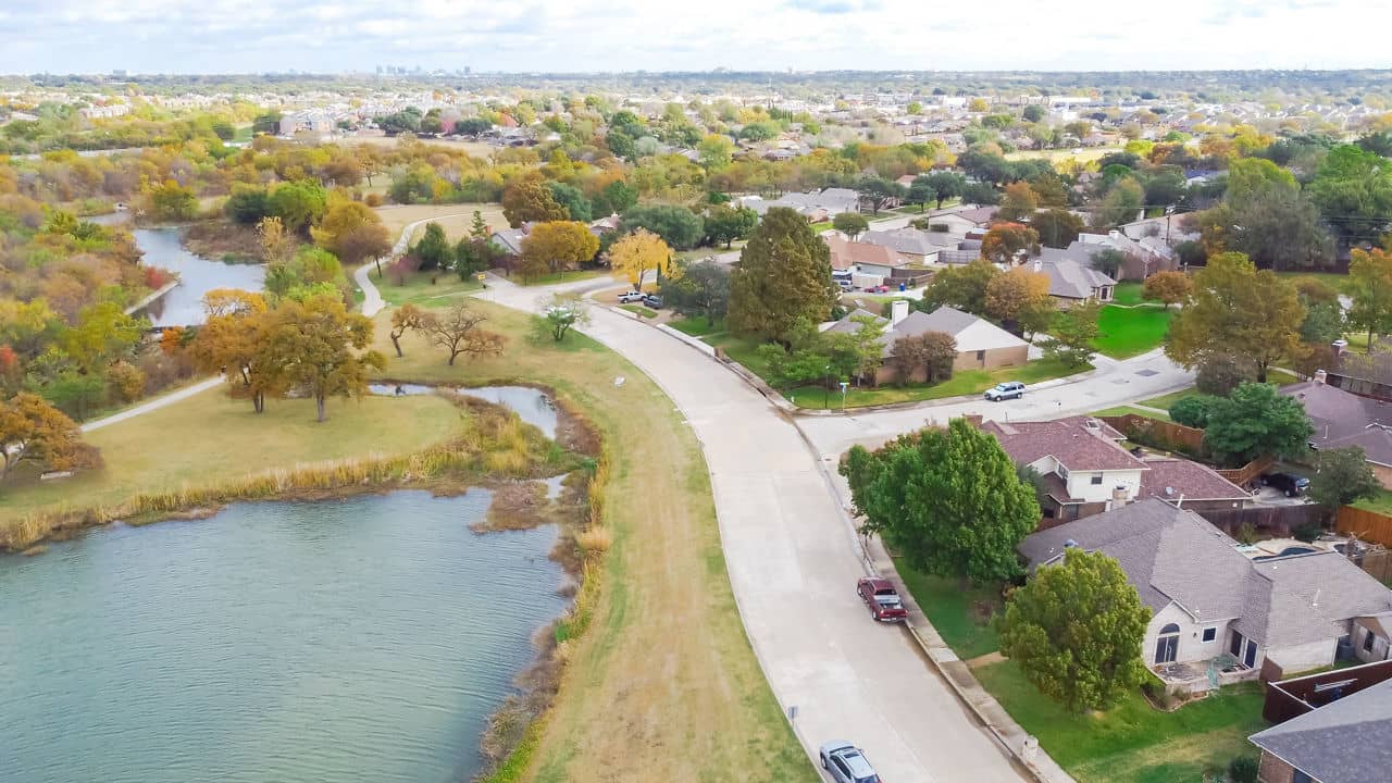 Aerial view of the Carrollton/Hebron neighborhood in Texas, featuring homes and lush greenery spread across a hilly landscape.