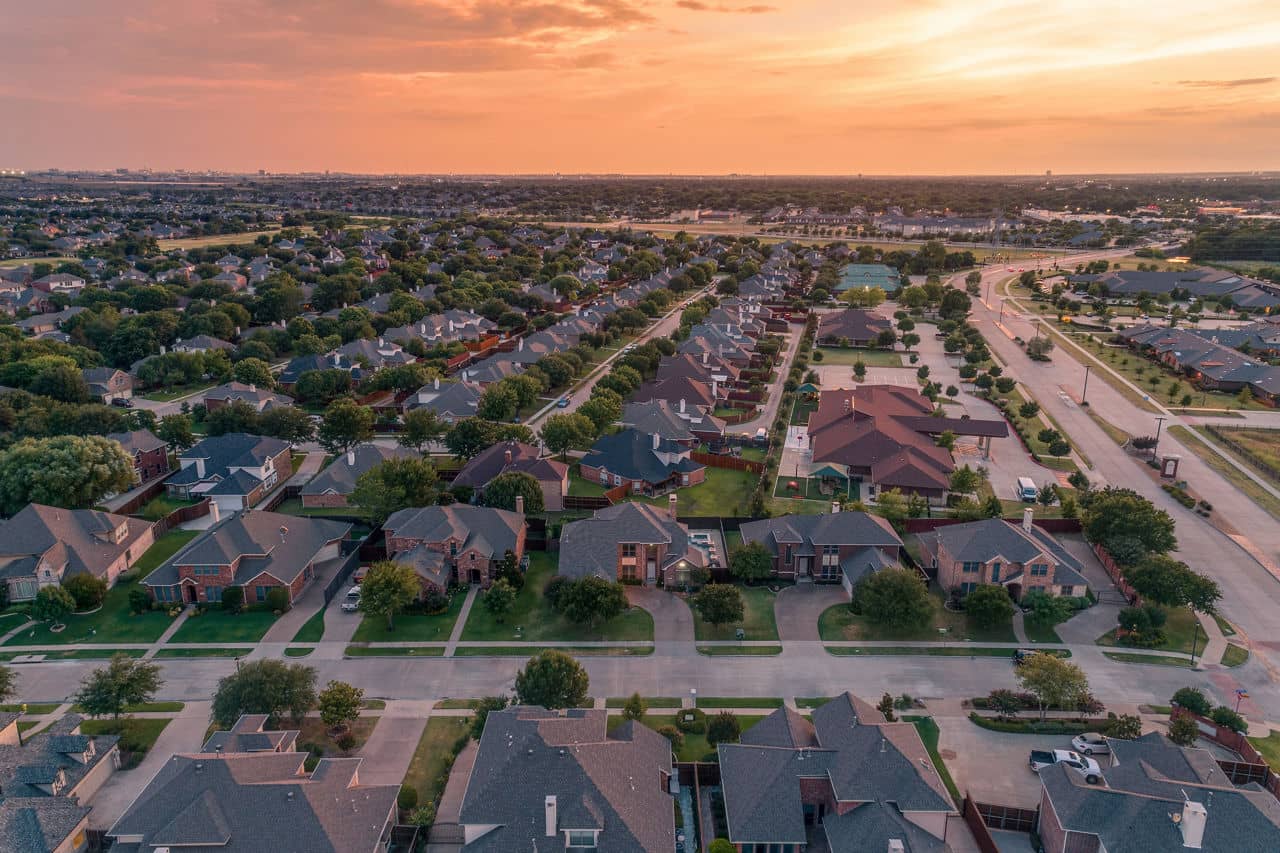 Aerial view of Coppell, Texas, showing houses, a park, and community buildings with trees and parking areas.