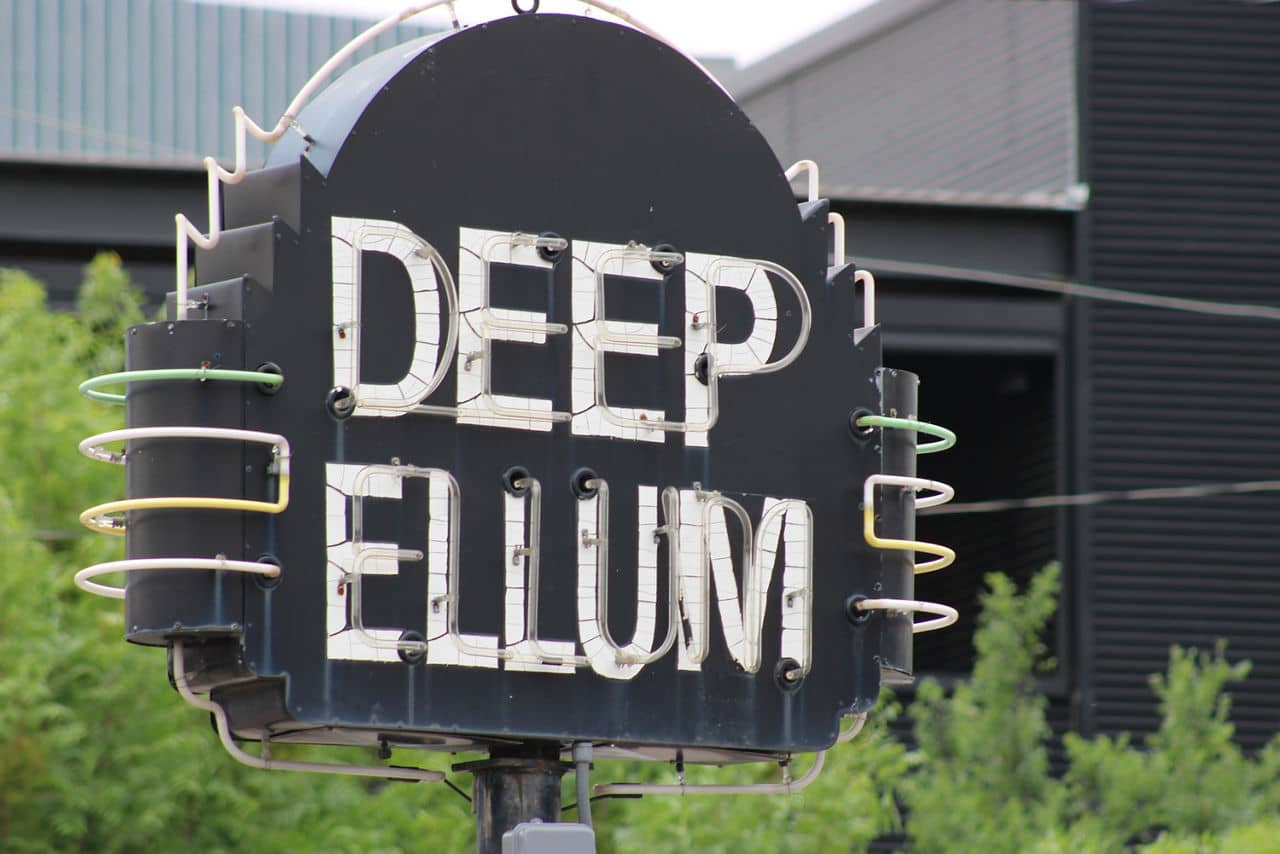 Sign for Deep Ellum, a vibrant neighborhood in Texas, featuring bold letters against a dark background.