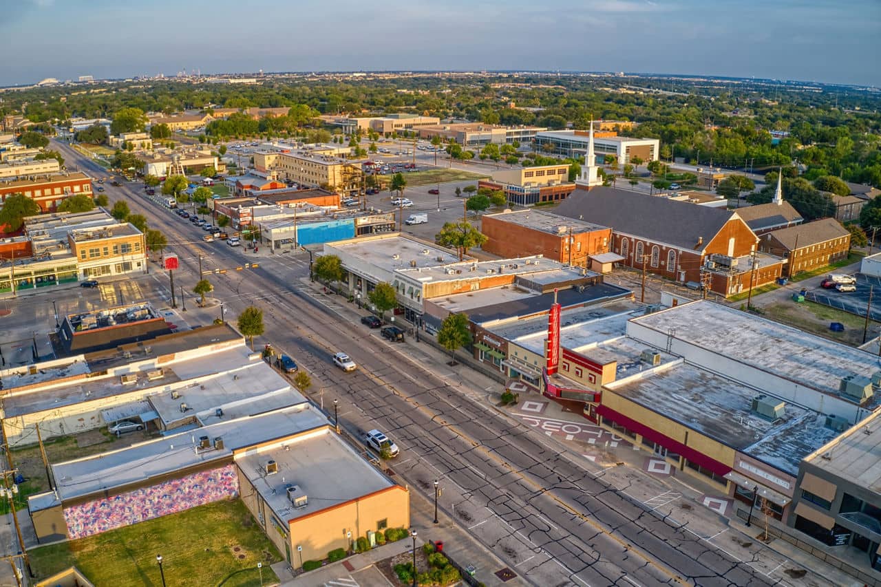 Aerial view of Grand Prairie, Texas, showing shops, streets, and buildings in a lively neighborhood.