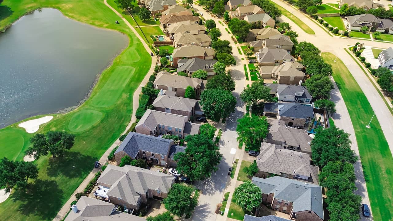 Aerial view of Fairway Bend neighborhood in Texas, showcasing houses, trees, and a nearby pond.