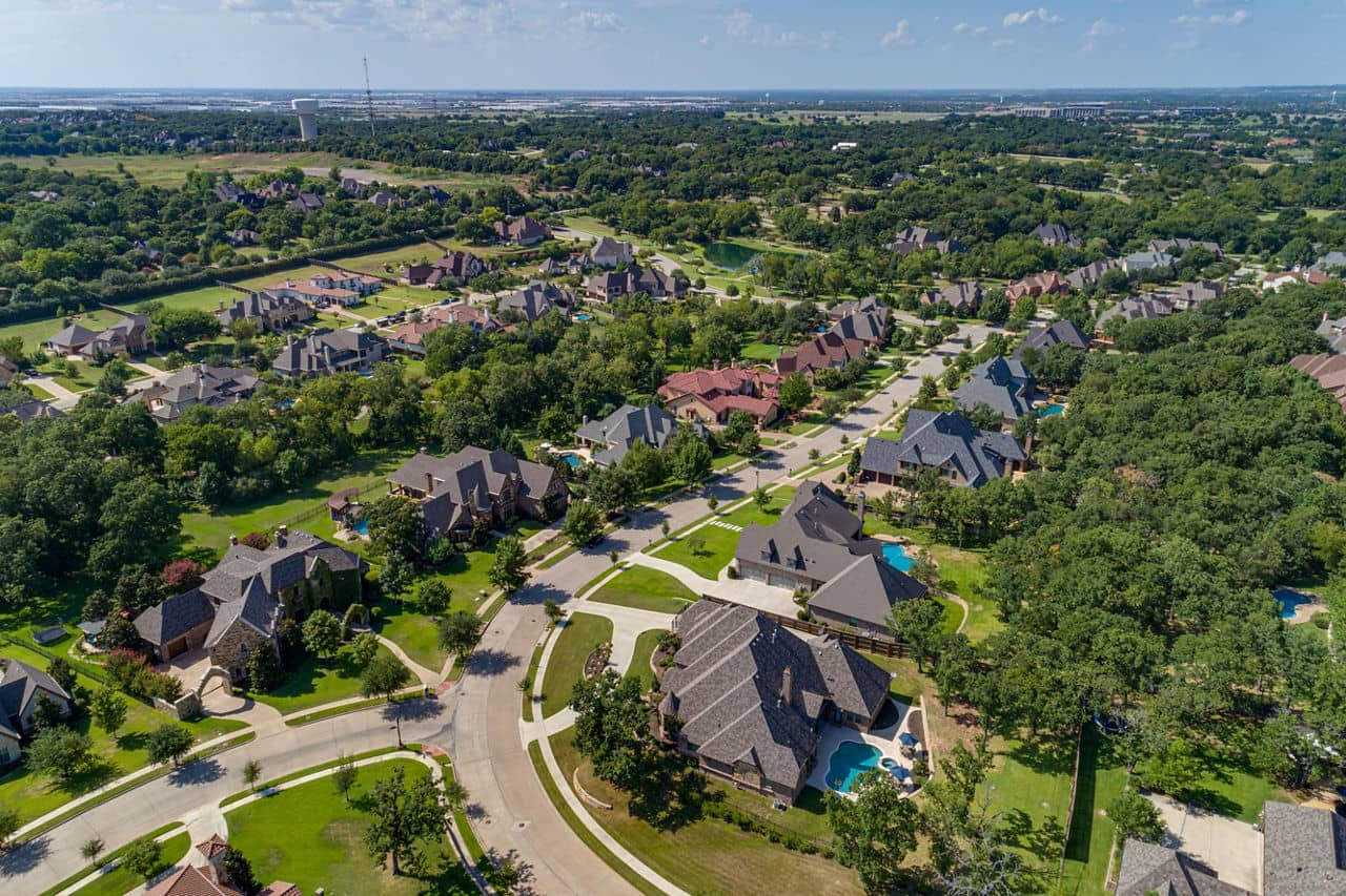 Aerial view of the Keller neighborhood in Texas, featuring spacious homes and green trees under a clear blue sky.