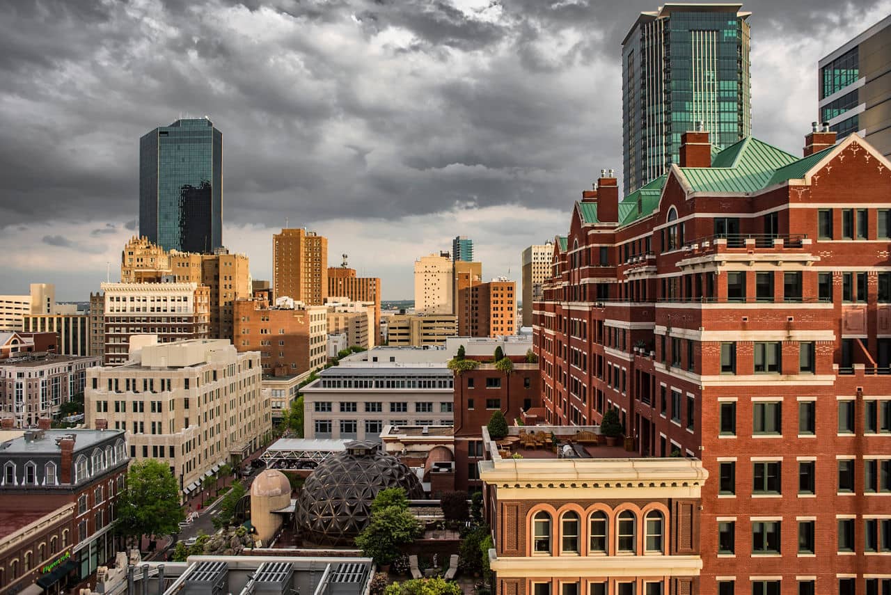 A skyline view of Sundance Square in the Upper West Side of Texas, featuring tall buildings and dark, cloudy skies.
