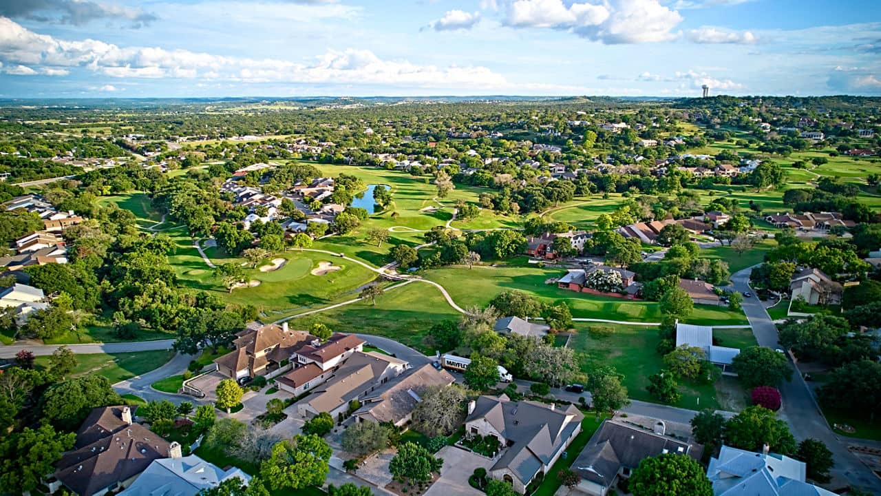 A bird&apos;s-eye view of the surroundings of residential buildings and beautiful green fields. Houston, Texas, USA