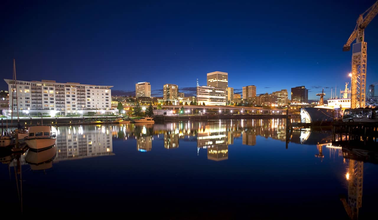 Night falls behind the Tacoma skyline and boats on Thea Foss Waterway